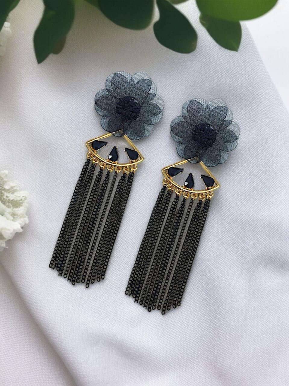 Dangling from the flower is a gold-tone, fan-shaped